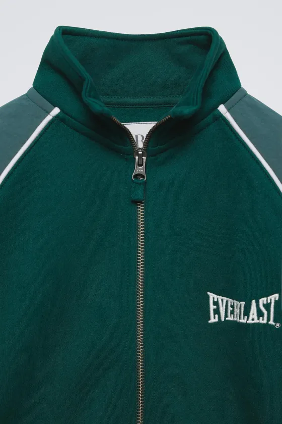 КОМБИНИРОВАННАЯ ТОЛСТОВКА С НАШИВКОЙ EVERLAST © WORLDWIDE INC.